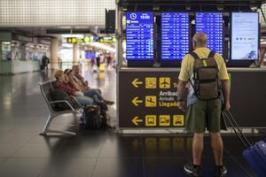 Un hombre mira un panel de llegadas y salidas en el Aeropuerto de El Prat. EP