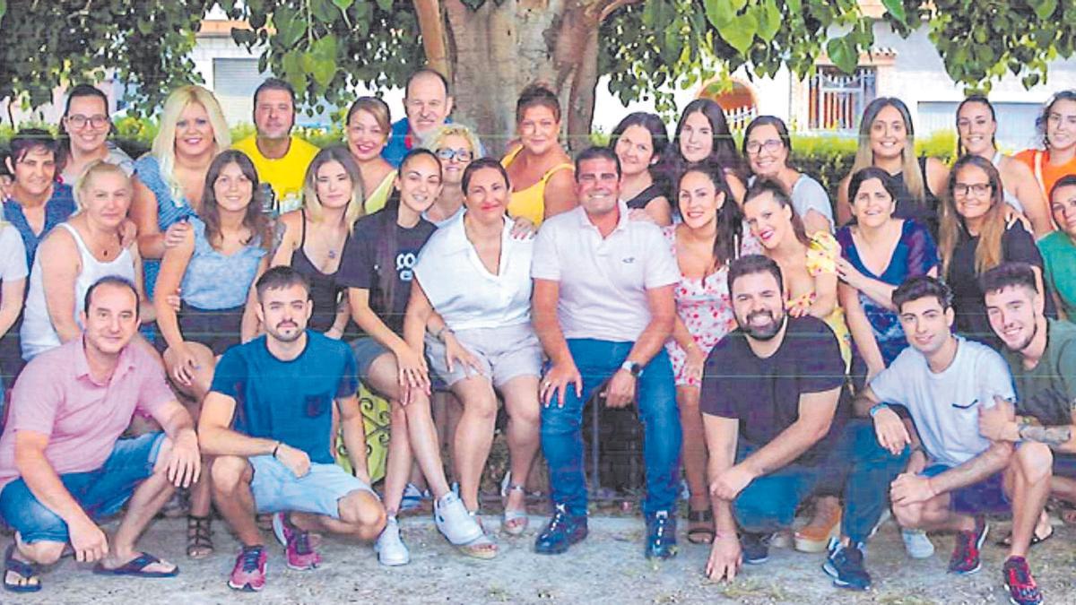 Grupo de festeros y festeras de las fiestas del Barrio del Cristo de Aldaia 2022, con la Reina de la Fiestas, Juani Moreno, en el centro de la imagen.