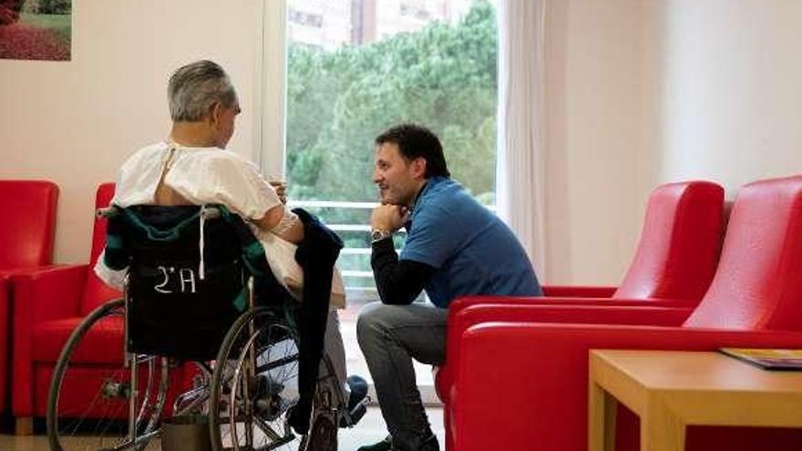 Un voluntario de la Caixa y Caixabank, con un paciente de una residencia de mayores.