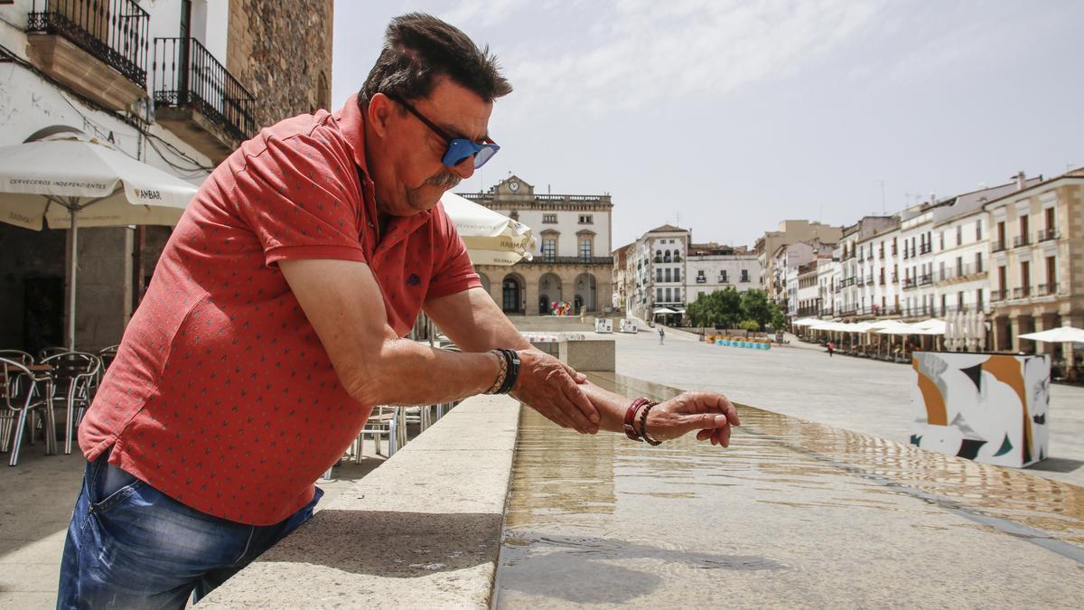 Un hombre se refresca en una de las fuentes de la plaza Mayor de Cáceres. En julio pasado se llegó a una máxima absoluta e histórica de 44,9 grados.