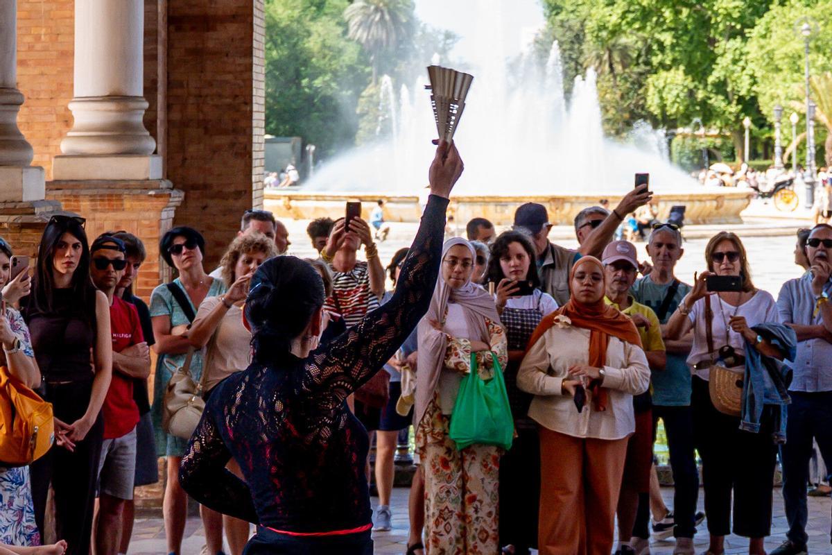 Los turistas contemplan un espectáculo flamenco en la Plaza de España de Sevilla.