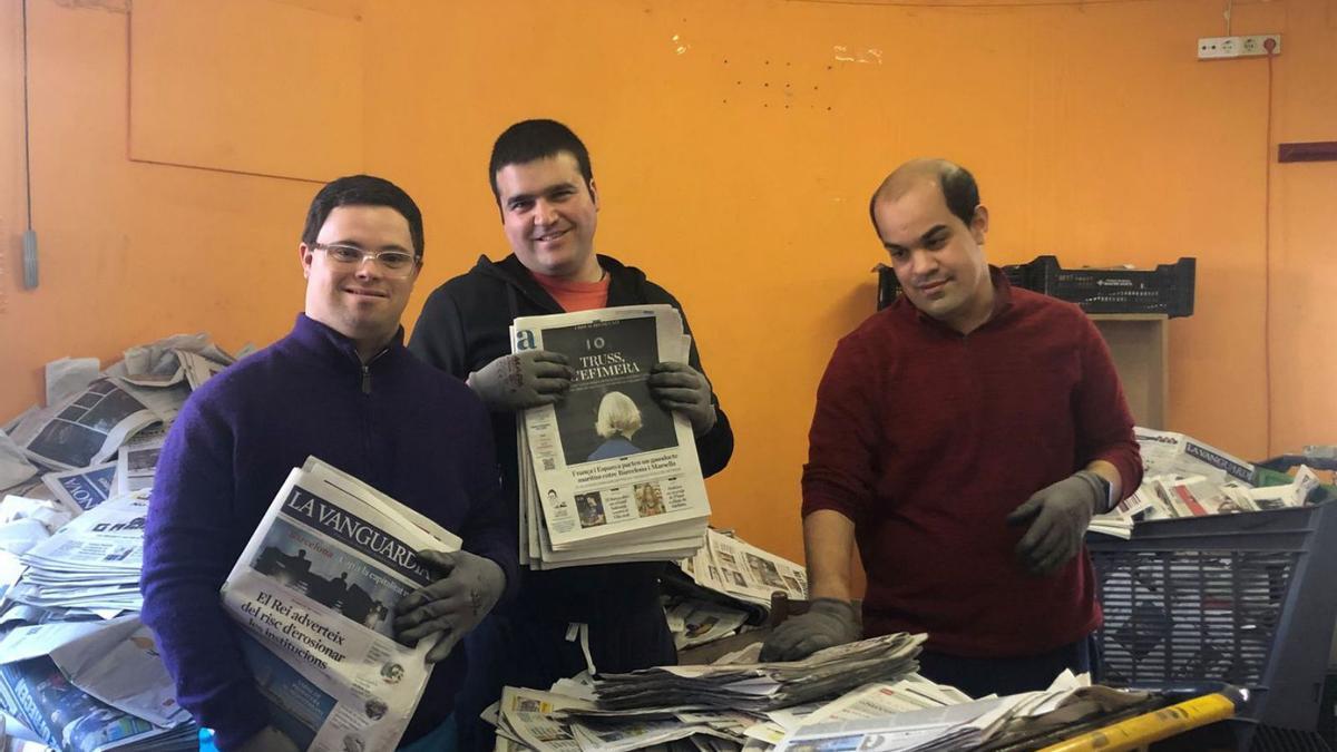 Usuaris de l’Associació El Tamariu separa el paper de diari reciclat per generar bales de paper. | JOANA PRADELL