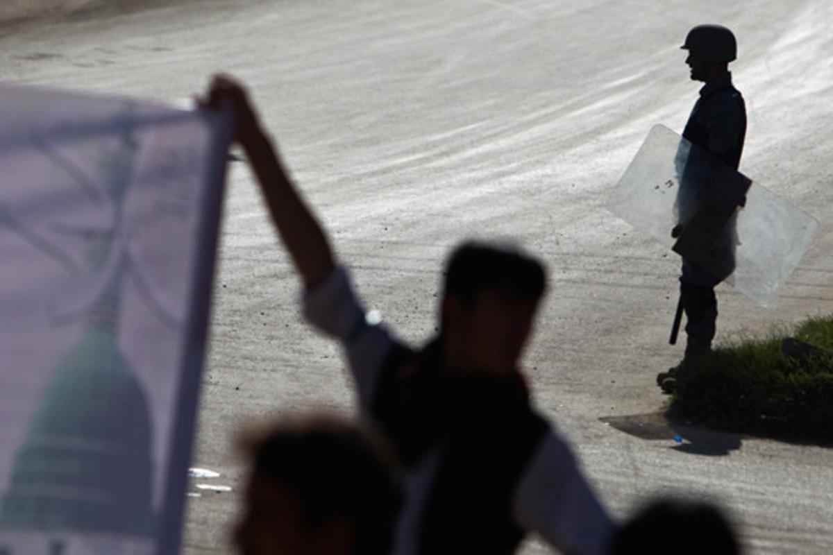 Un policia antiavalots manté la guàrdia durant una manifestació en protesta per l’assassinat de l’expresident afganès la setmana passada.
