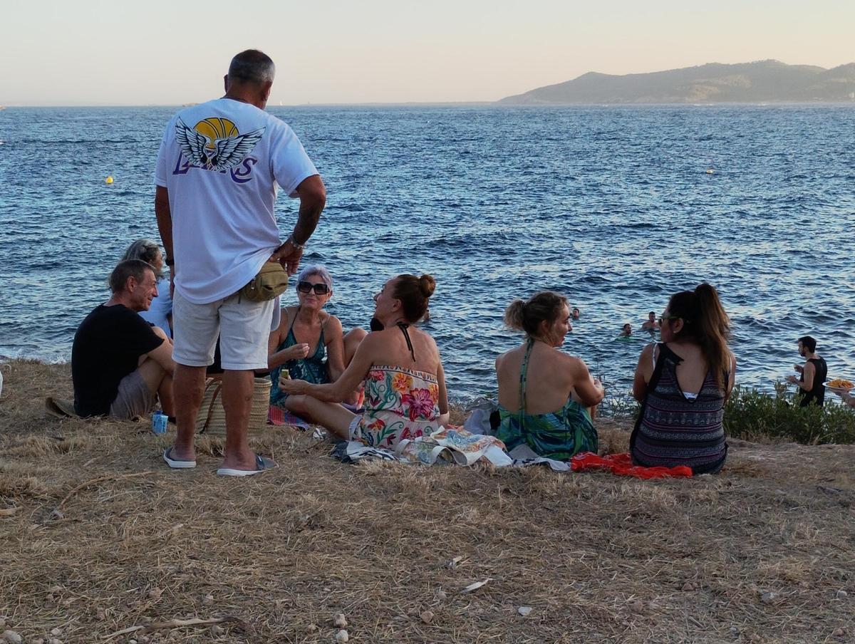 Familiares y amigos disfrutan de la comida y el baño durante las últimas horas de la tarde