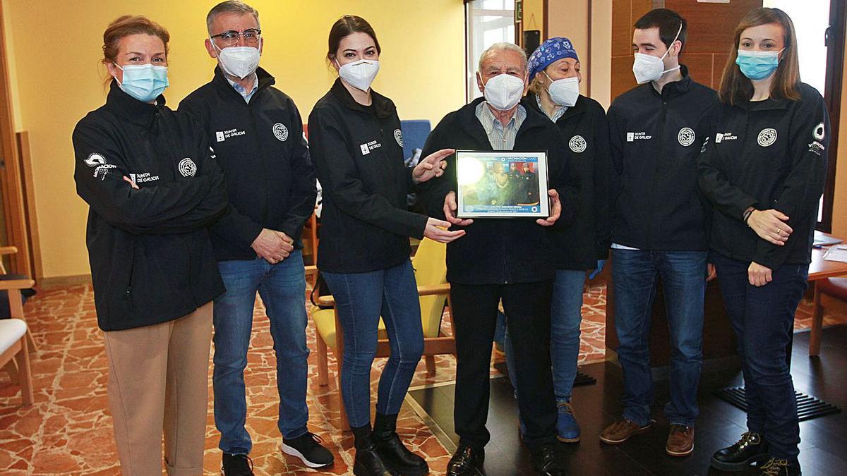 El equipo de enfermería que vacunó a Inocencio Corbal con una fotografía regalo en Cudeiro. |   // IÑAKI OSORIO