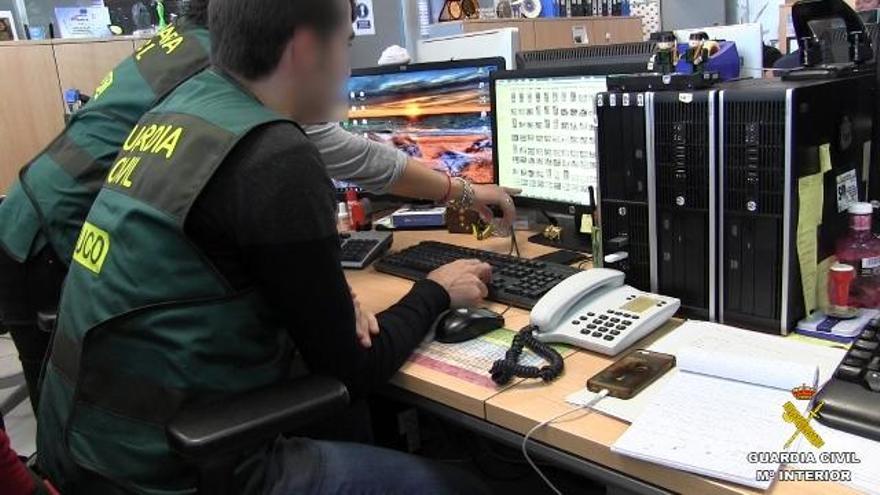 Imagen de la policía registrando el ordenador del detenido