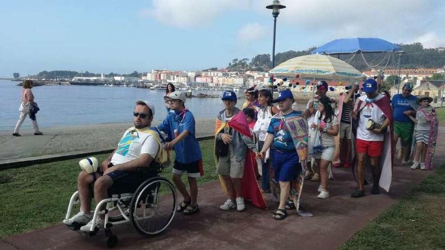 Arriba, miembros de colectivo de Aspamsim y del colegio Juan XXIII en la playa de Rodeira. Abajo, un cartel instalado por ellos en el arenal. // S.A.