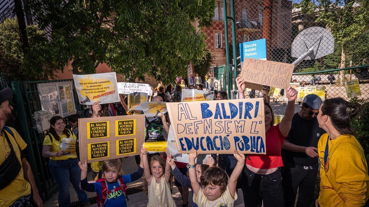 Familias en la puerta de la escuela Baldiri Reixac de Barcelona con pancartas pidiendo más recursos para la educación pública.