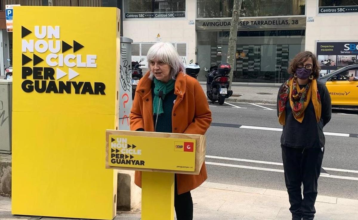 Dolors Sabater (CUP), con la número tres de la lista, Eulàlia Reguant, en rueda de prensa ante las oficinas de Haya Real Estate en Barcelona.
