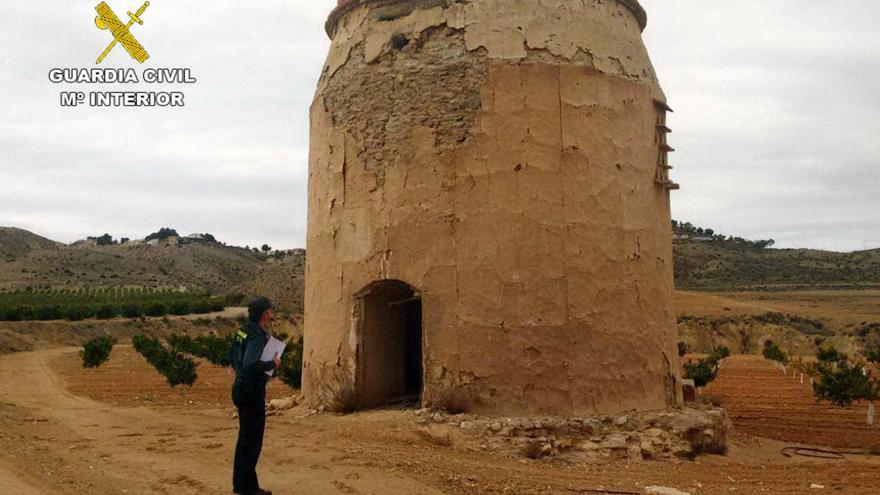 Un guardia civil observa la torre de un molino en las Salinas Reales de Sangonera la Seca.