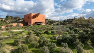 La almazara de Philippe Starck, un cubo rojo monolítico, con un inmenso cuerno de toro de acero