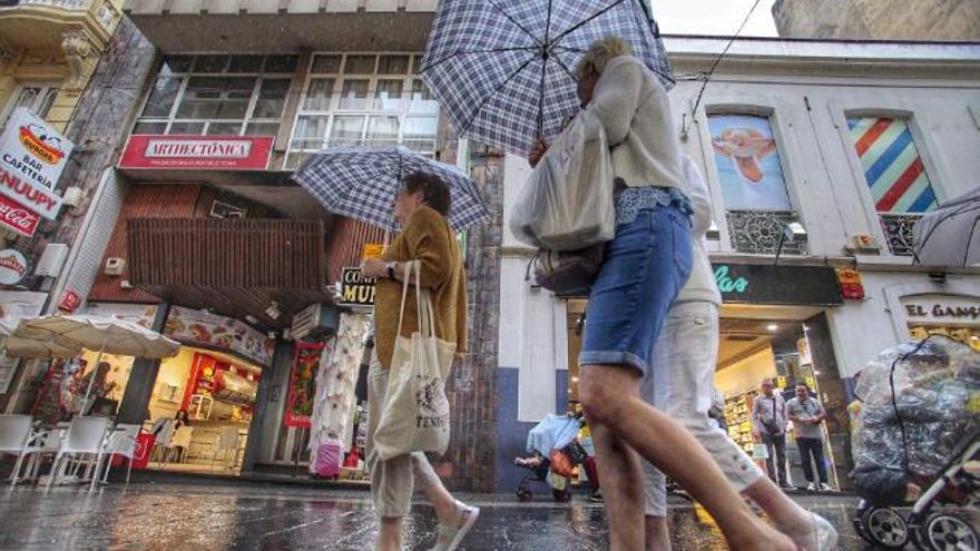 Viandantes pasean con sus paraguas por Santa Cruz de Tenerife el pasado sábado.