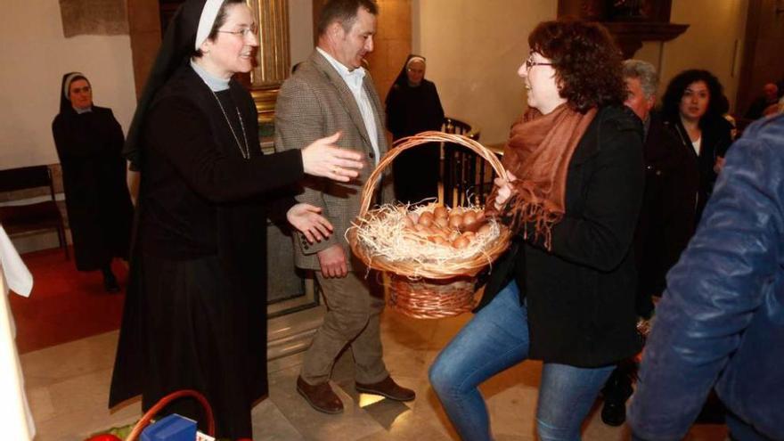 Una de las hermanas recibe una cesta con huevos de los sareganos.