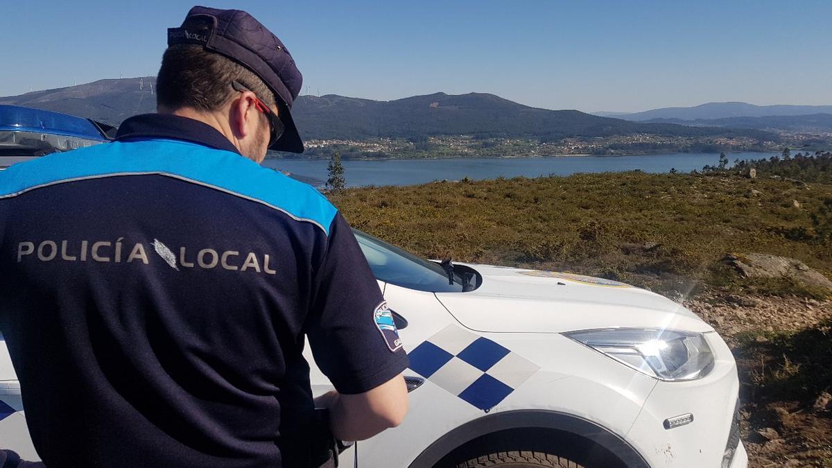 Un agente de la Policía Local de Rianxo, con el río Ulla al fondo.