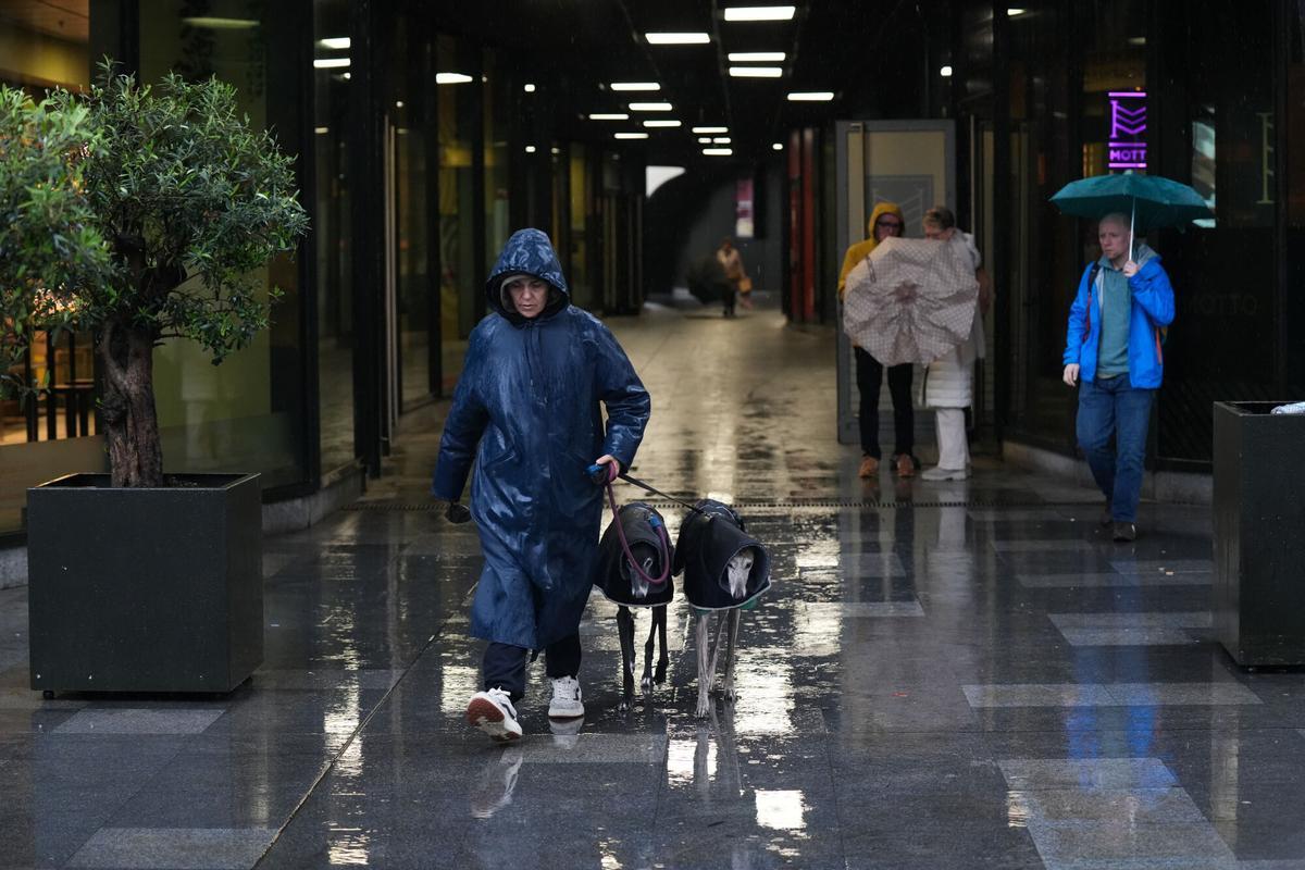 Transeúntes con paraguas en el centro de Sevilla durante el temporal de la borrasca Leonardo, que mantiene en alerta roja varios cauces de la provincia. Sevilla, España, 4 de febrero de 2026.
