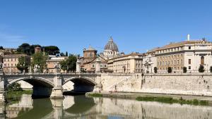Edificios en el centro histórico de Roma, con el río Tíber en primer plano y la cúpula de San Pedro del Vaticano al fondo.