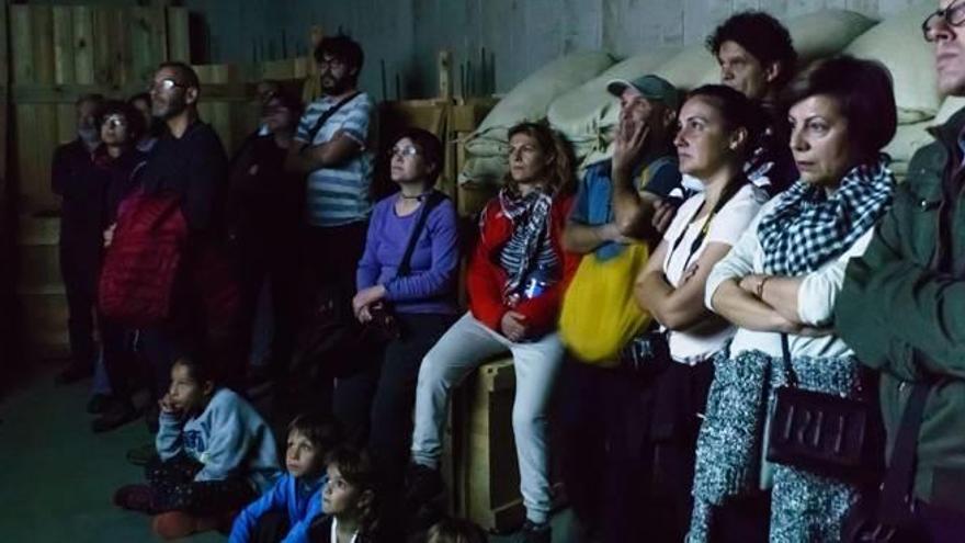 Un grup de visitants al centre d&#039;interpretació del Parc dels Búnquers mirant un documental