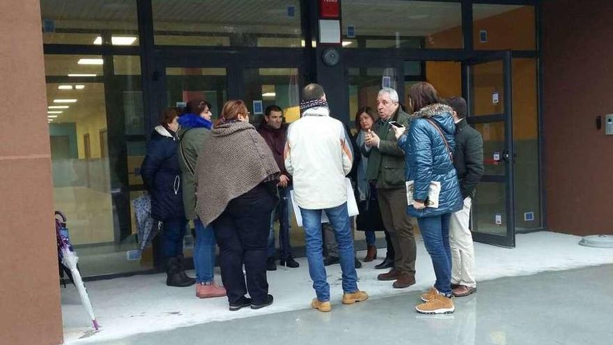 Indalecio Cabana atiende a padres de alumnos, el miércoles, ante el nuevo colegio de Rutis.