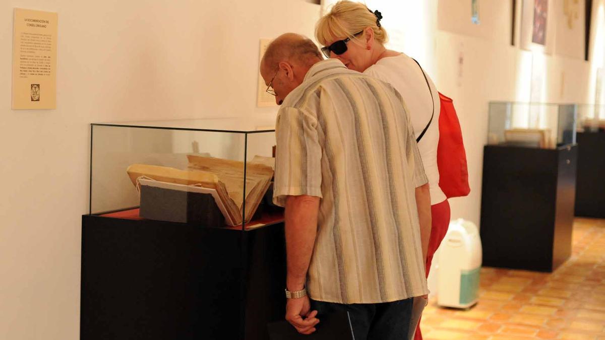 Turistas ven el Llibre dels Repartiments en la muestra donde se expuso en 2010, tras su cesión por unos días a Orihuela.