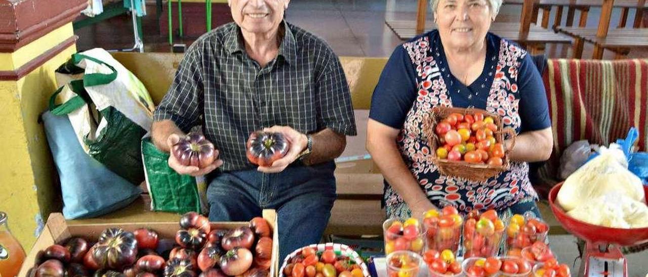 Mario Costales, con tomates azules, y Mercedes Álvarez, en su puesto de la plaza de Villaviciosa.