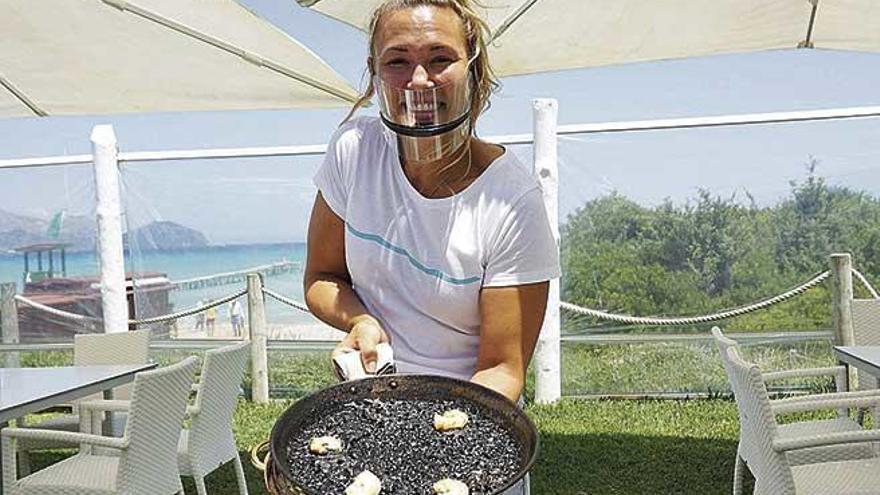 Marga Daniel con una paella de arroz negro.