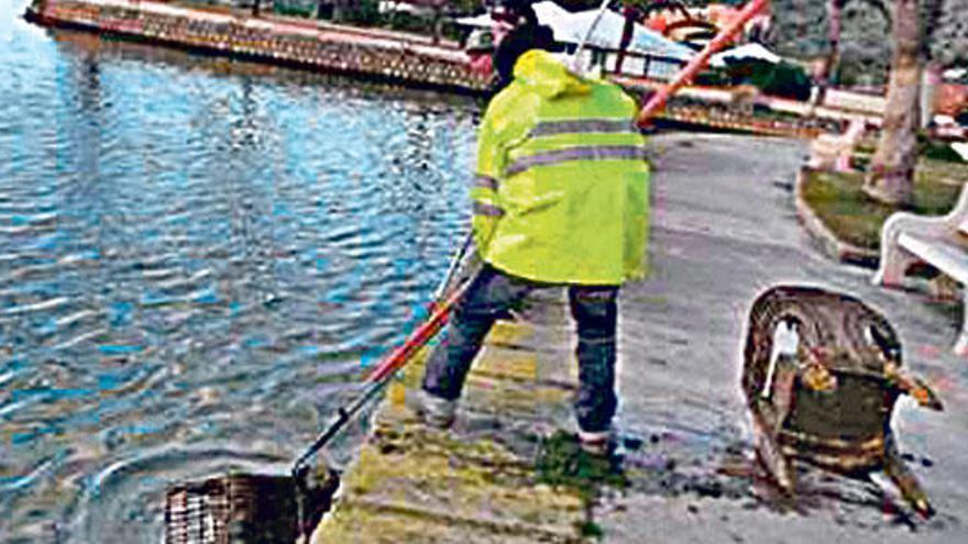 Un operario extrae residuos del lago Esperanza.