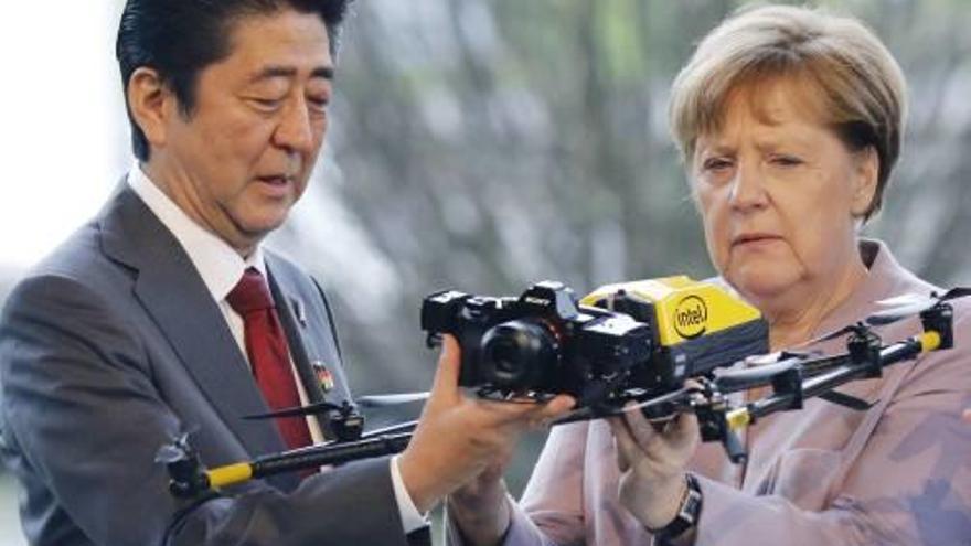 Abe i Merkel examinen un dron a Hannover.