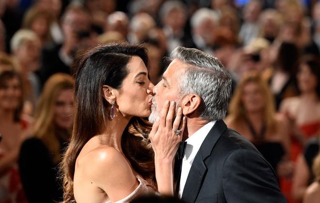 Amal le da un beso a George Clooney antes de recibir su premio AFI