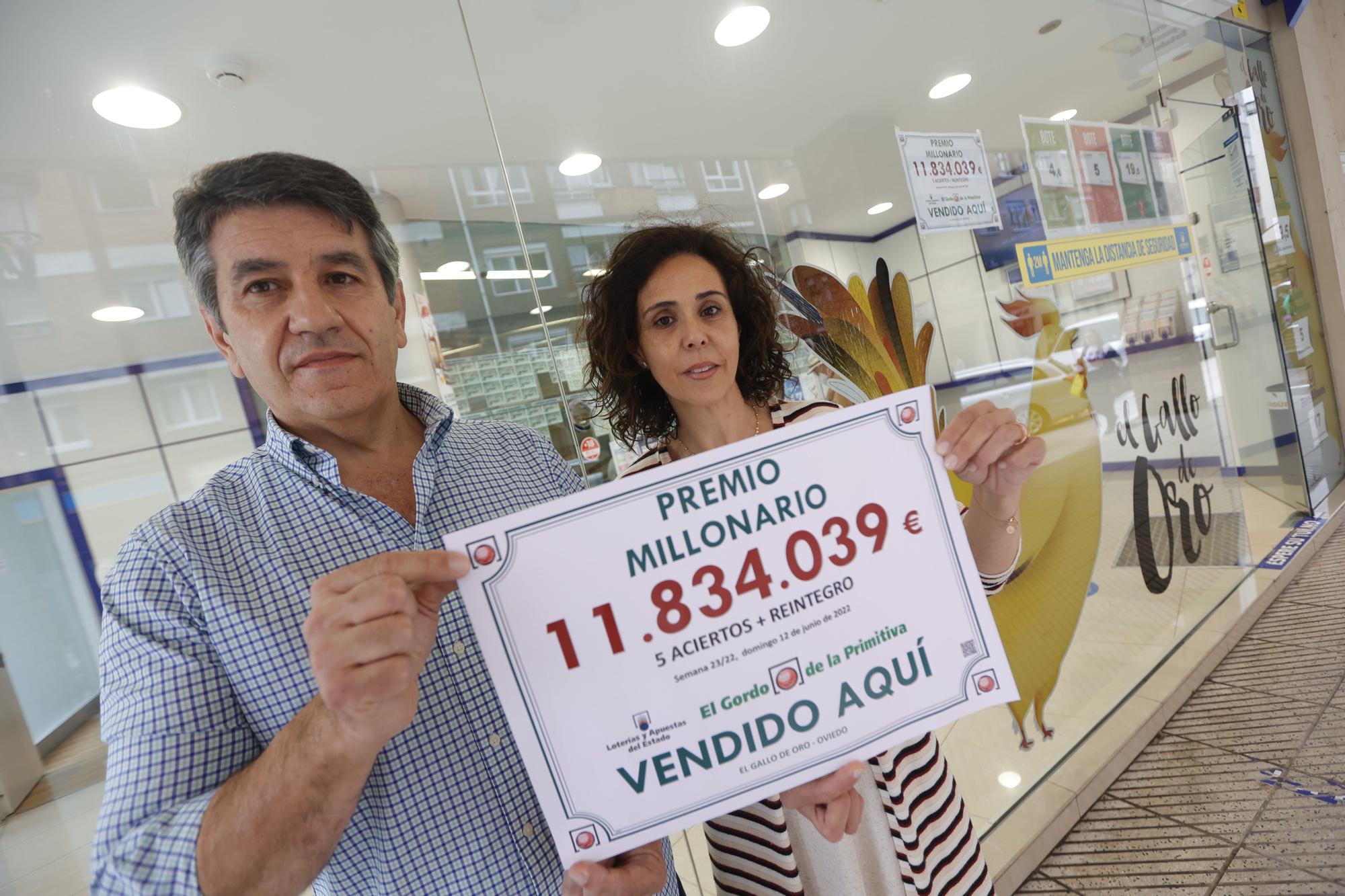 Froilán Blanco y Sandra Rodríguez, con el cartel del premio de 11,8 millones de euros del Gordo de la Primitiva vendido en su administración del Cristo.