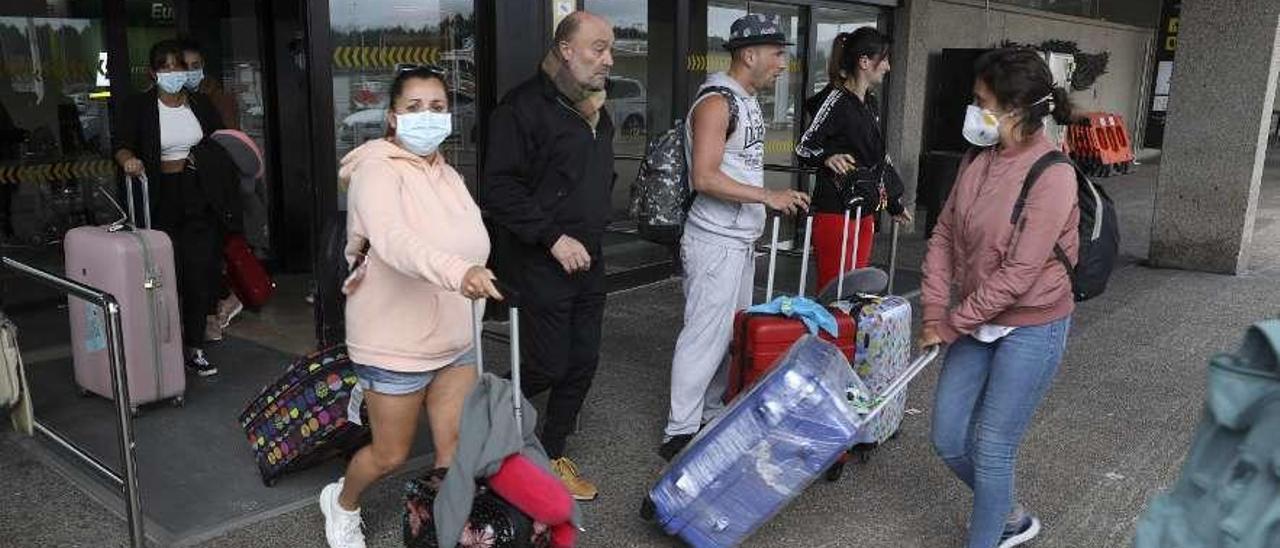 Isabel Sánchez, con mascarilla, tirando de dos maletas en la puerta de llegada del aeropuerto.