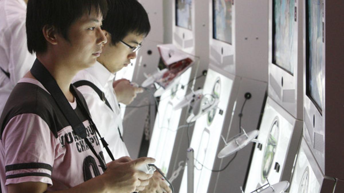 Dos jóvenes juegan con la Xbox 360 de Microsoft, durante una feria de videojuegos en Tokio.