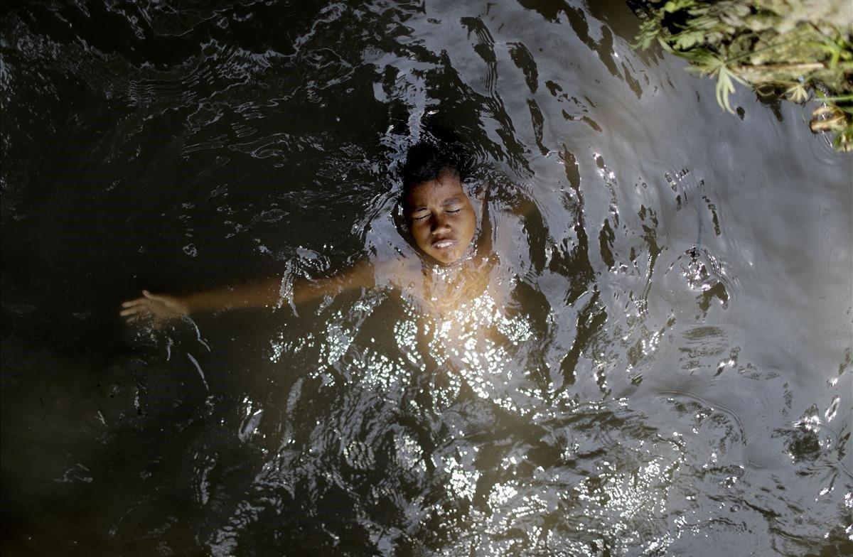 Un niño se baña en un arroyo en Caracas, Venezuela.