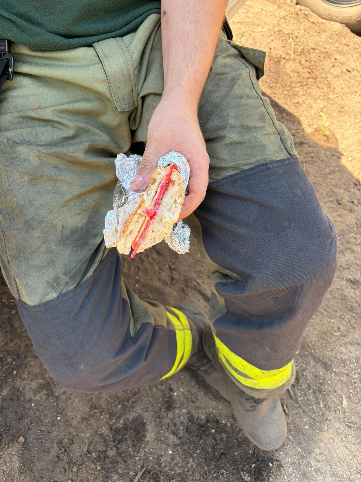 Un bombero come un bocadillo tras una jornada frente al fuego.