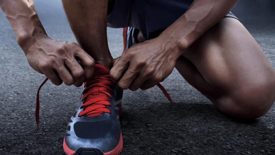 Un atleta se anuda los cordones.