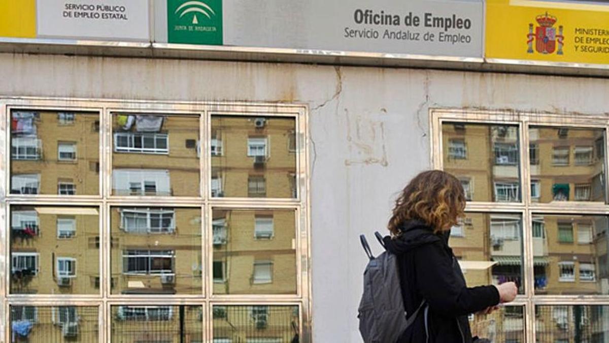 Una mujer frente a una oficina de empleo.