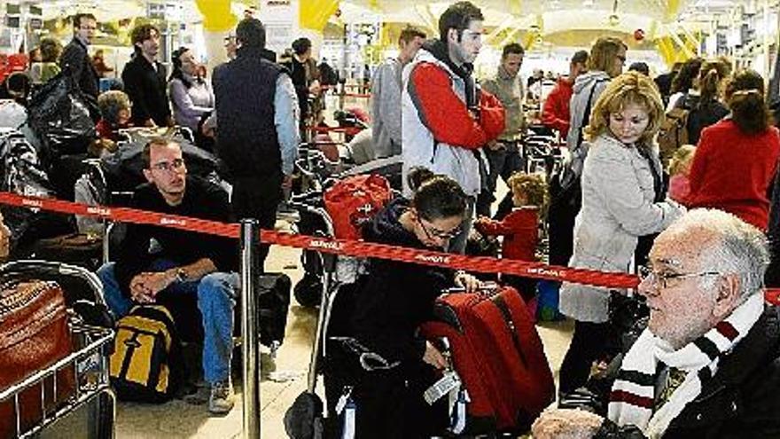 Diversos passatgers asseguts a l&#039;espera de rebre notícies sobre els seus vols cancel·lats ahir a l&#039;aeroport de Barajas.