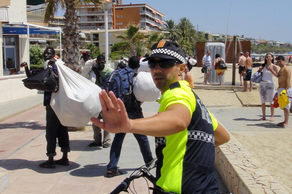Un grup de manters i un policia a Cambrils, dissabte passat. Un grup de manters i un policia a Cambrils, dissabte passat.