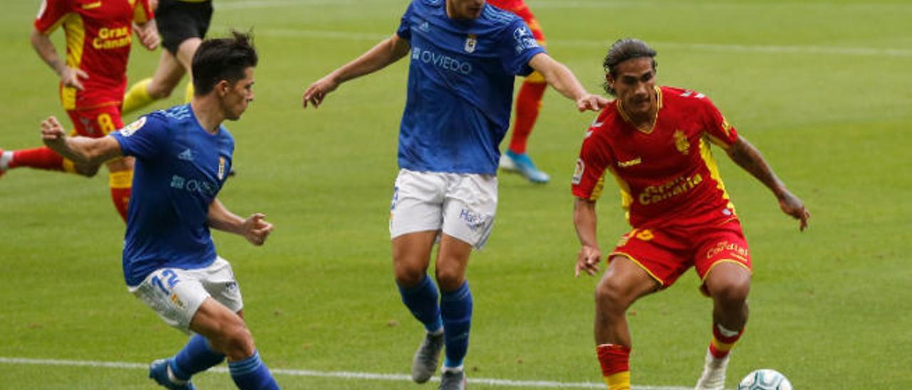 Fede Varela, que salió en la segunda parte, conduce el balón rodeado por dos jugadores del Oviedo, con Aridai detrás.