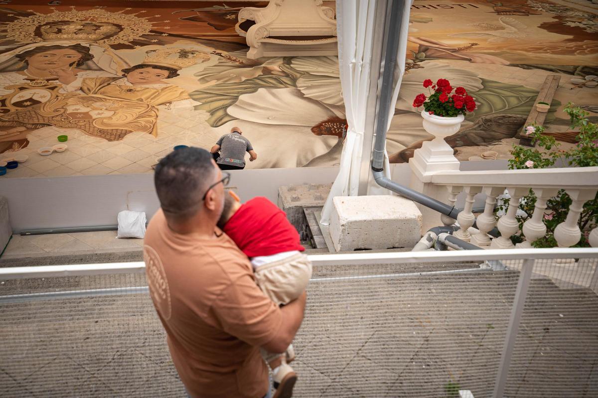 Padre e hijo observando la preparación de la alfombra