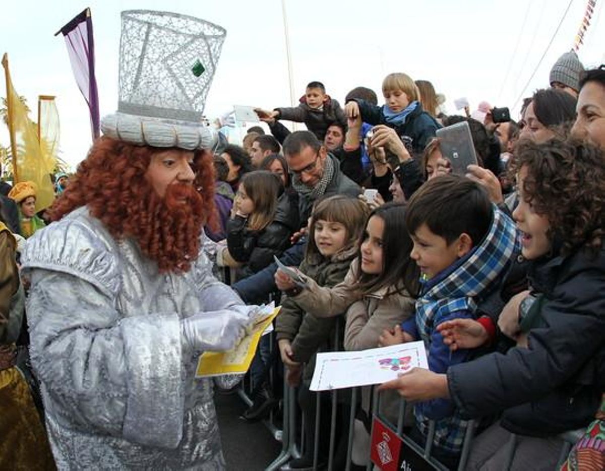 El rei Melcior recollint algunes de les cartes dels nens que s’han reunit al Moll de la Fusta per veure els Reis Mags.