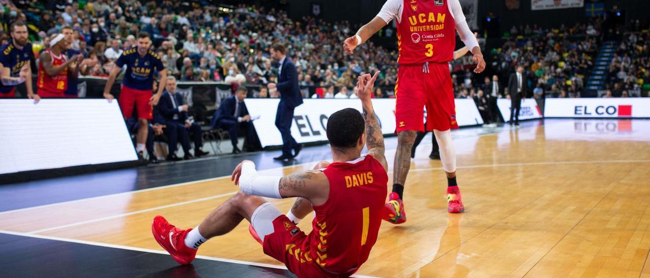 James Webb III ayuda a Jordan Davis a levantarse del parqué de Miribilla en el partido ante el Bilbao Basket. | PRENSA UCAM MURCIA CB