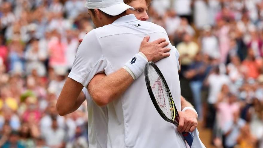 Isner y Anderson se abrazan agotados tras el maratoniano partido de ayer en Wimbledon.