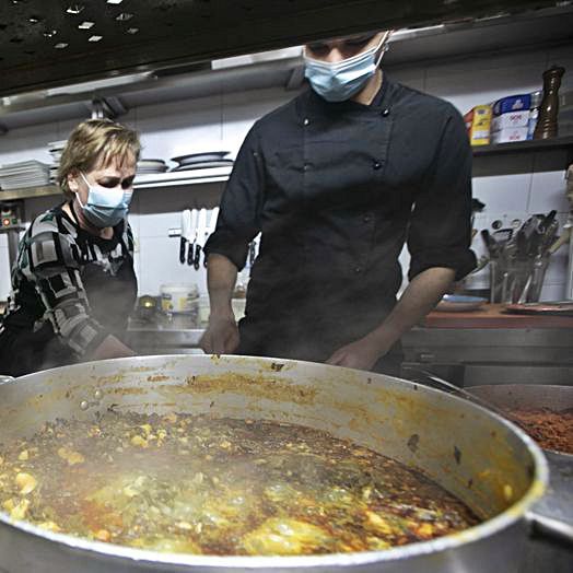 Emilia Fernández y Nelson Hernández, ante una gran olla de pote. 