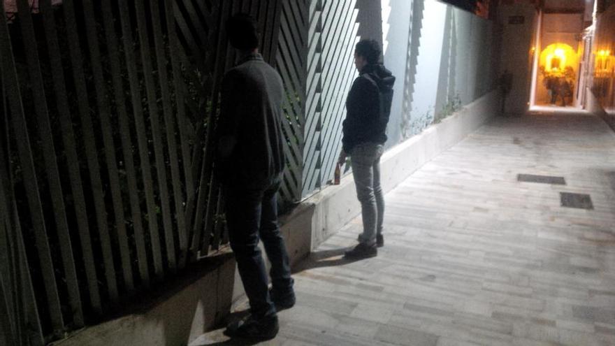 Dos jóvenes miccionan en la calle Soledad.