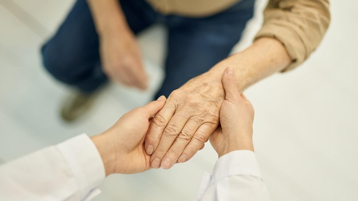 Médico examinando la función de la mano de un paciente mayor.