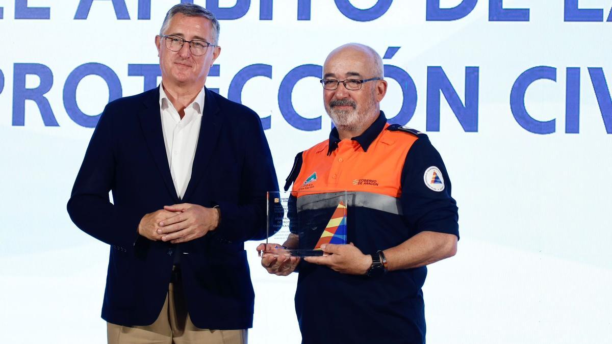 Antonio Prados, presidente de la Agrupación de Voluntarios de Protección Civil (AVPC) de la Sierra de Albarracín, recibe la condecoración de manos de Manuel Blasco, consejero de Medioambiente y Turismo del Gobierno de Aragón.