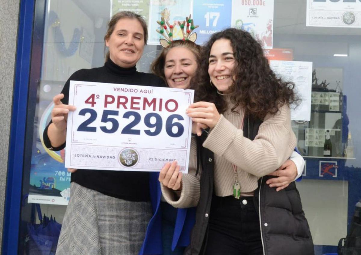 Julia González, Olga Gómez y Sheila Souto, con el cartel del 25296; y los viticultores brindan por el premio en el sorteo de Navidad.  | // G. NÚÑEZ