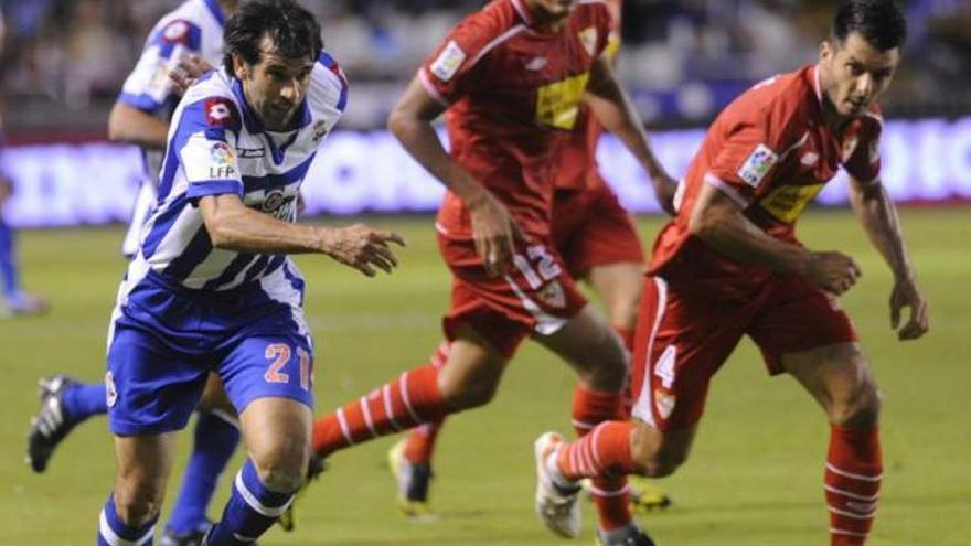 Valerón trata de progresar ante Spahic en el encuentro ante el Sevilla en Riazor. / juan varela