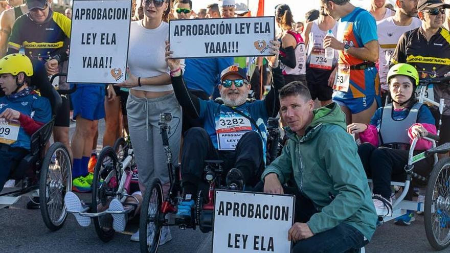 Un afectado reclama la aprobación de la ley ELA durante la media maratón de Alicante