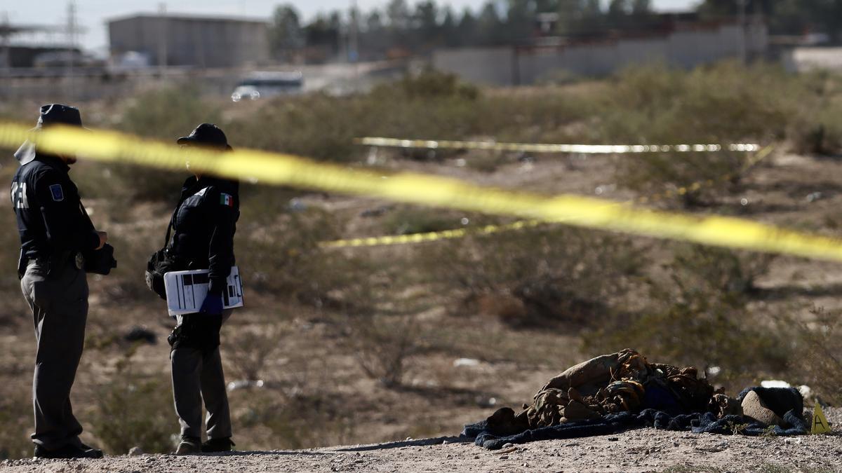 Personal de la policía municipal resguardan la zona donde se localizó una fosa clandestina con seis cuerpos, este jueves en Ciudad Juárez (México).